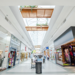 A photograph of Portones Shopping Mall showing walkway with storefronts on either side.
