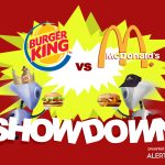 A graphic with a yellow starburst in the center and two robots charging towards each other. Both are carrying hamburgers and wearing hats. Text reads "AlertBot Showdown: Burger King vs McDonald's" with the word SHOWDOWN very large at the bottom.