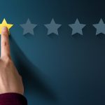 A finger resting on a yellow star with four blank stars to the right of it, meaning it's a 1 star rating.