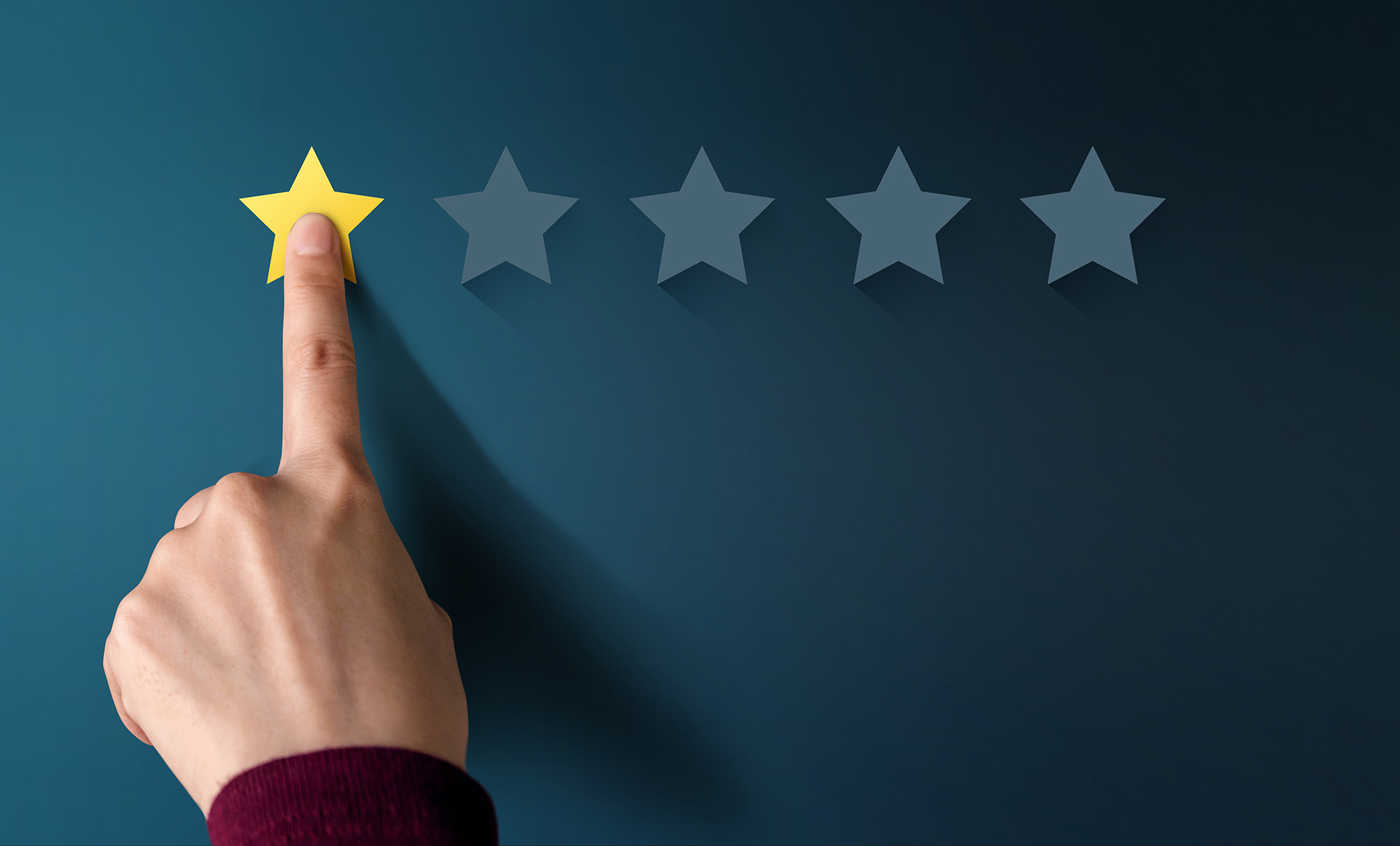 A finger resting on a yellow star with four blank stars to the right of it, meaning it's a 1 star rating.