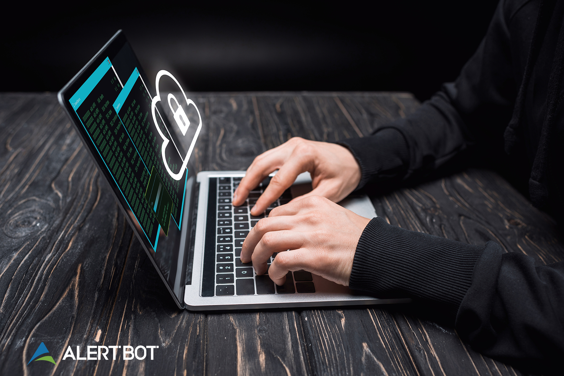 A laptop sitting on a wooden desk with two hands resting on the keyboard. Two browser windows are shown on the screen at an angle, with the graphic of a cloud and a lock floating in front of the screen.